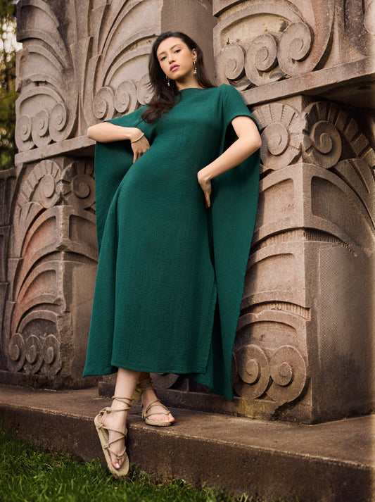 Model wearing a Diana cotton gauze cape caftan in pine green.