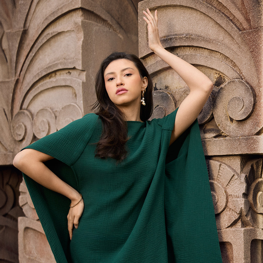 Model wearing our Diana cape caftan in pine green double gauze.
