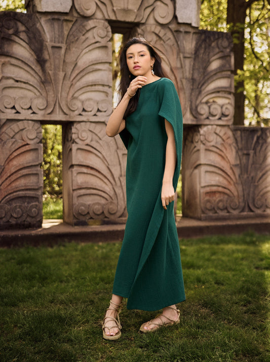 Model wearing a Diana cotton gauze cape caftan in pine green. 